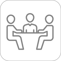 Three people sitting at a table helping 